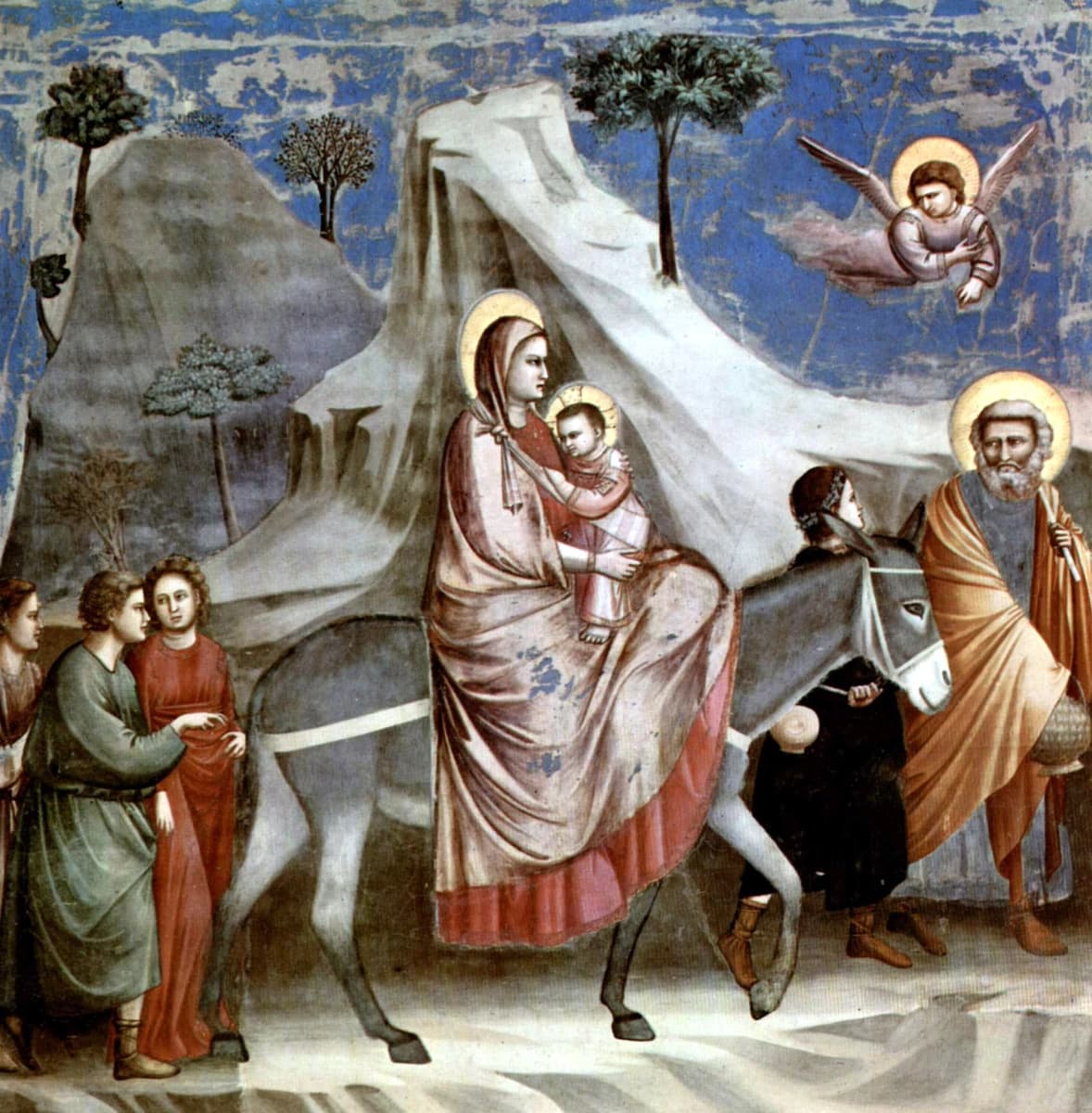 Giotto di Bondone, Flight into Egypt, 1303–1305 — a woman in a pink robe holding a child rides a grey donkey led by a youth, a bearded man in an ochre cloak walks at the right, three figures follow at the left, and an angel flies above, all before a pale grey rock rising to a peak and a flaking blue ground