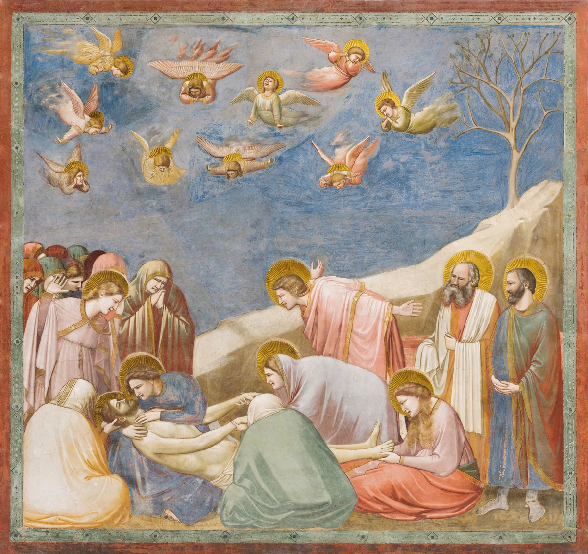 Giotto di Bondone, Lamentation, 1303–1305 — a square fresco inside a red and green painted frame: ten mourners on one ground line around a dead figure at the lower left, a diagonal rock wedge running down from the upper right, a bare tree, and ten small angels in a flat blue ground above